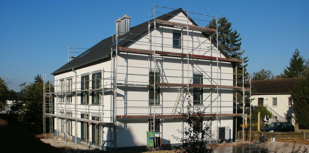 Ein sich im Aufbau befindendes Haus mit Rüstung davor